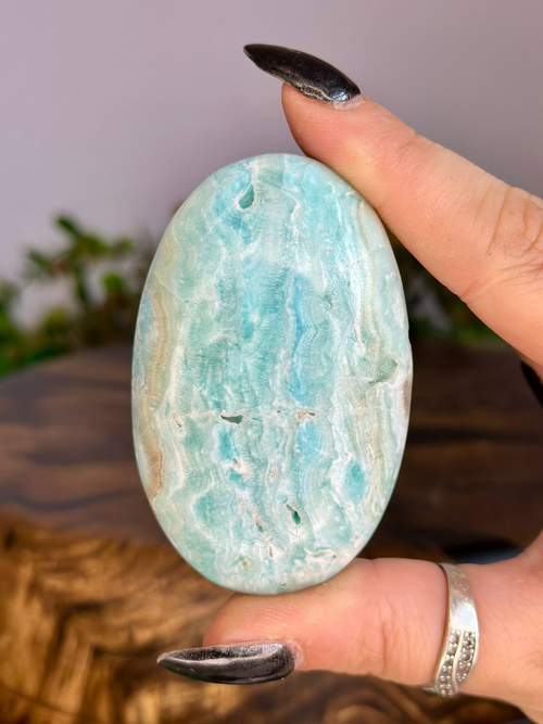 Polished Blue Aragonite palm stone with aqua blue and creamy white natural banding