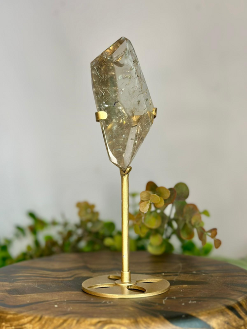 Side view of polished Brazilian Smoky Quartz on custom gold stand showing its pale champagne smoky colouring