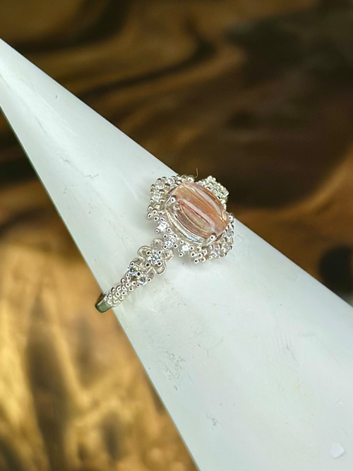 Side view of Copper Rutilated Quartz sterling silver ring showing translucent oval gemstone and decorative silver shoulders