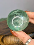 Green Fluorite sphere 189g with translucent green colour and natural rainbow inclusions