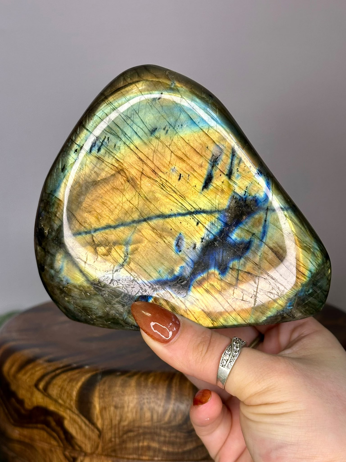 Large 12 x 11cm Labradorite freeform held in hand showing scale and golden blue flash