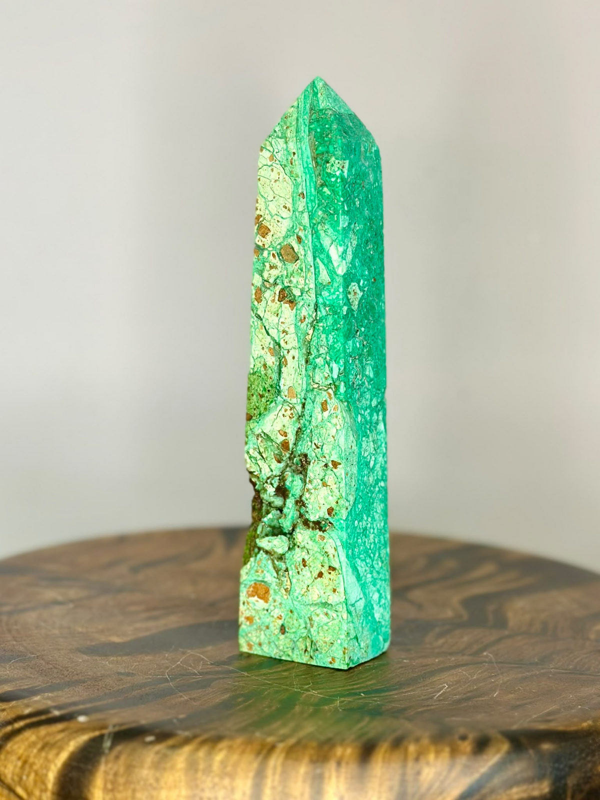 Side view of natural Pakistan Chrysoprase polished tower showing bright green mineral patterns